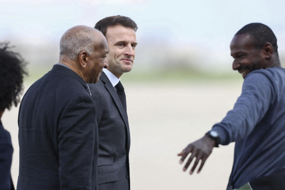 French President Emmanuel Macron, center, greets with family members freed French hostage journalist Olivier Dubois, right, who was held hostage in Mali for nearly two years, upon his arrival at the military airport in Villacoublay, near Paris, Tuesday, March 21, 2023. (Yves Herman, Pool via AP)