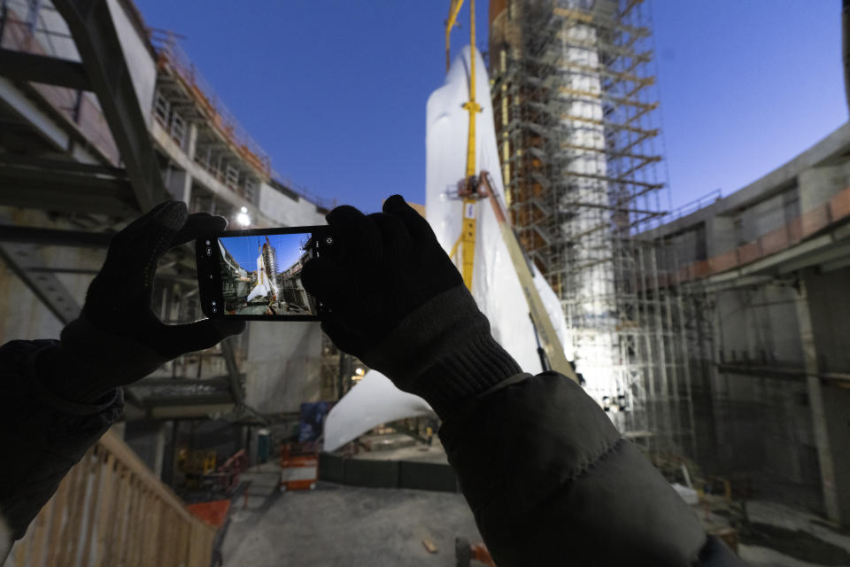 People take photos of Space Shuttle Endeavour at the site of the future Samuel Oschin Air and Space Center on Tuesday, Jan. 30, 2024, in Los Angeles. NASA's retired Space Shuttle Endeavour was carefully hoisted late Monday to be mated to a huge external fuel tank and its two solid rocket boosters at a Los Angeles museum where it will be uniquely displayed as if it is about to blast off. (AP Photo/Richard Vogel)