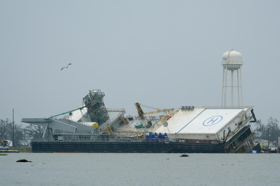 Water surrounds a damaged barge Friday, Aug. 28, 2020, in Cameron, La., after Hurricane Laura moved through the area Thursday. (AP Photo/David J. Phillip)