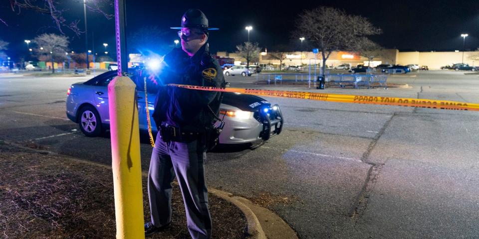 A Virginia State Trooper re-ties crime scene tape as law enforcement work the scene of a mass shooting at a Walmart, Wednesday, Nov. 23, 2022, in Chesapeake, Va.