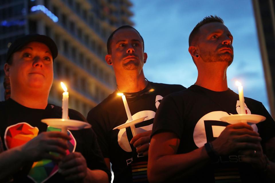 People hold candles as they attend a one year anniversary memorial service for victims of the mass shooting. (Photo by Joe Raedle/Getty Images)