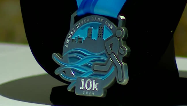 Race officials show off the design for the medals for the upcoming 2024 Amway River Bank Run. (WOOD TV8)