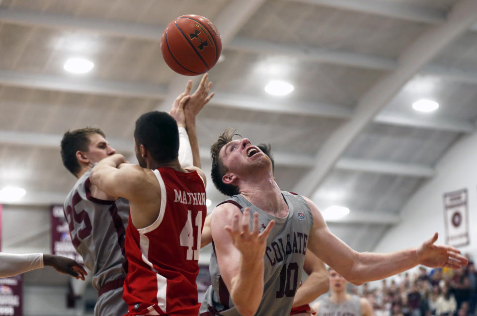 Boston University's Sukhmail Mathon (41) battles for a rebound between Colgate's Rapolas Ivanauskas 925) and Will Rayman (10) in the second half of the NCAA Patriot League Conference basketball championship at Cotterell Court, Wednesday, March 11, 2020, in Hamilton, N.Y. (AP Photo/John Munson)