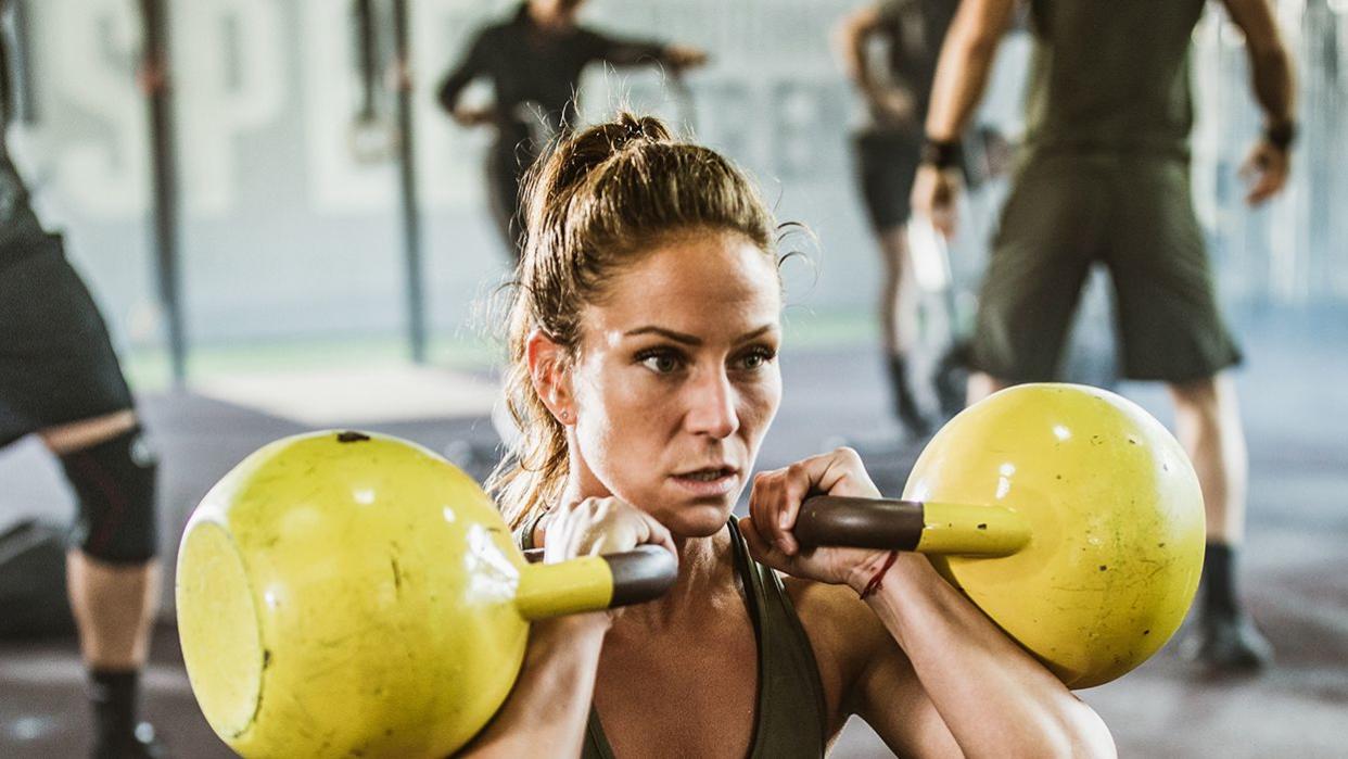 Woman performing a kettlebell squat and kettlebell front squat