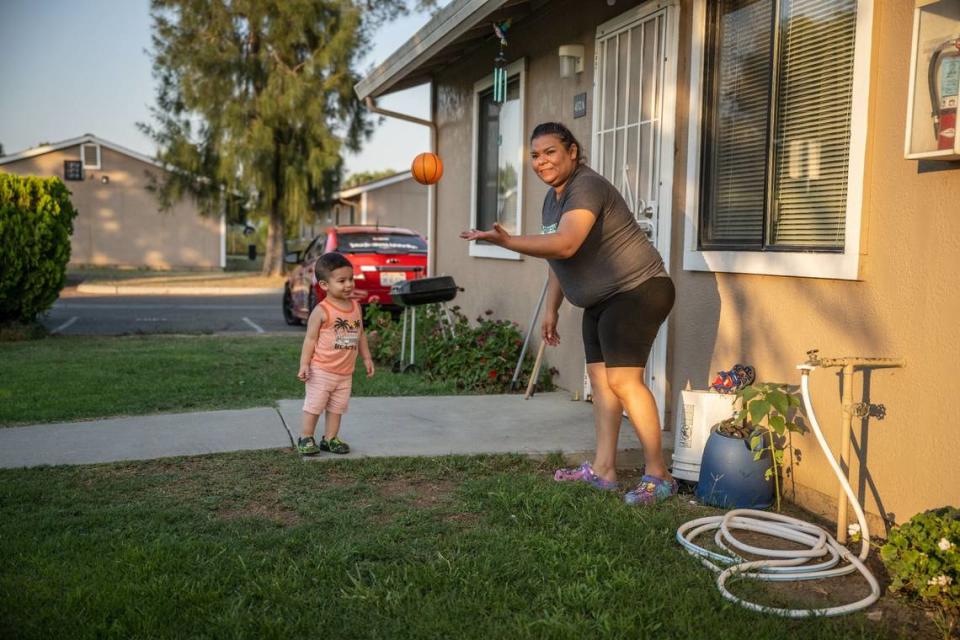 Jessica Vela hold plays ball with her son Jannick Dariel Chapa at their apartment at the Williams Migrant Center in July. Vela works as a migrant farmworker near Williams because she’s not able to earn a living as a dentist in her Mexican village.