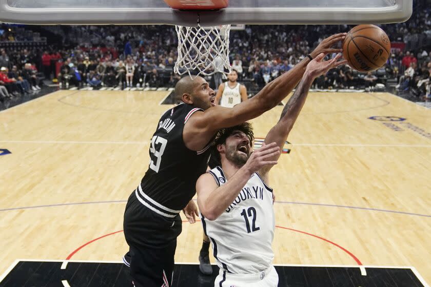 Los Angeles Clippers forward Nicolas Batum, left, blocks a shot by Brooklyn Nets forward Joe Harris (12) during the first half of an NBA basketball game Saturday, Nov. 12, 2022, in Los Angeles. (AP Photo/Marcio Jose Sanchez)