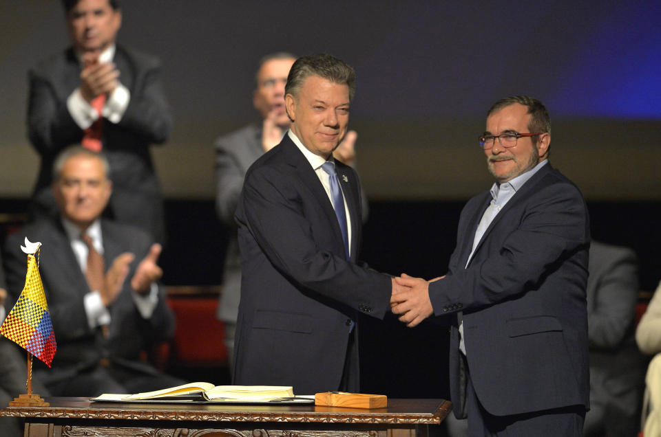 Then Colombian President Juan Manuel Santos and Timoleon Jimenez, aka Timochenko, the head of FARC, shake hands during the second signing of the historic peace agreement in Bogota, Colombia, on Nov. 24, 2016. (Luis Robayo / AFP via Getty Images)