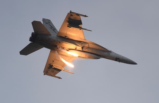 A Royal Australian Air Force  (RAAF) F/A-18F Super Hornet  drops two flares as it performs during the T150 Defence Force Air Show on October 15, 2016, in Townsville, Australia. Boeing's military division was on track to sell the Royal Canadian Air Force a handful of Super Hornet jet fighters in 2017, but the deal went sideways.  (Ian Hitchcock/Getty Images - image credit)