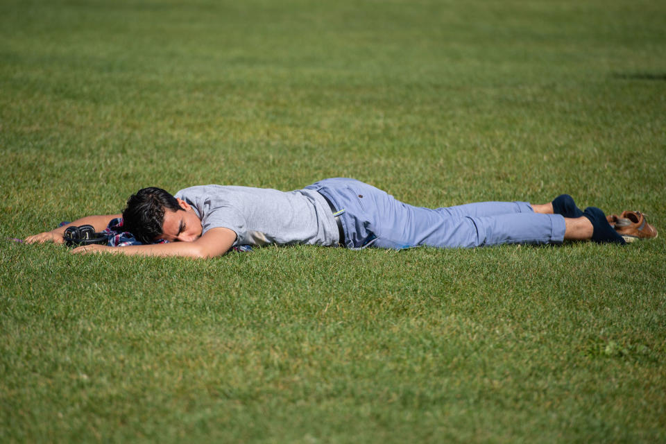 A man relaxes on the grass as he enjoys a period of sunshine on Primrose Hill in London on Saturday (Picture: PA)