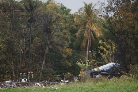 Firefighters work at the wreckage site of a Boeing 737 plane that crashed in the agricultural area of Boyeros, around 20 km (12 miles) south of Havana, shortly after taking off from Havana's main airport in Cuba, May 18, 2018. REUTERS/Alexandre Meneghini