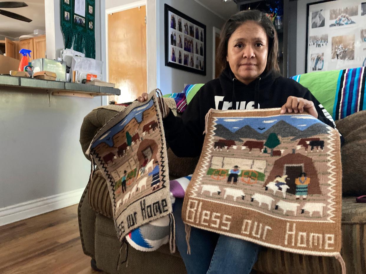 Seraphine Warren poses for a photo in her home in Tooele, Utah, on Sept. 23, 2021, with a rug made by her aunt, Navajo rug weaver Ella Mae Begay.