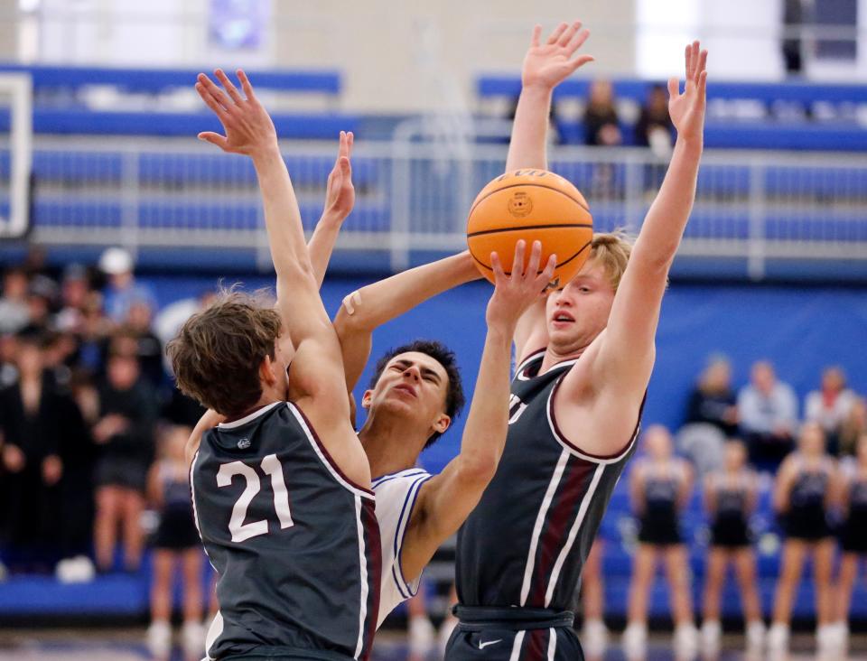 Deer Creek's Clyde Davis, Jr.,  shoots in between Edmond Memorial's Hudson Franz, left, and Kade Walter during the championship boy's game of the Bruce Gray tournament between Edmond Memorial and Deer Creek at Deer Creek High School, Saturday, Jan.21, 2023. 