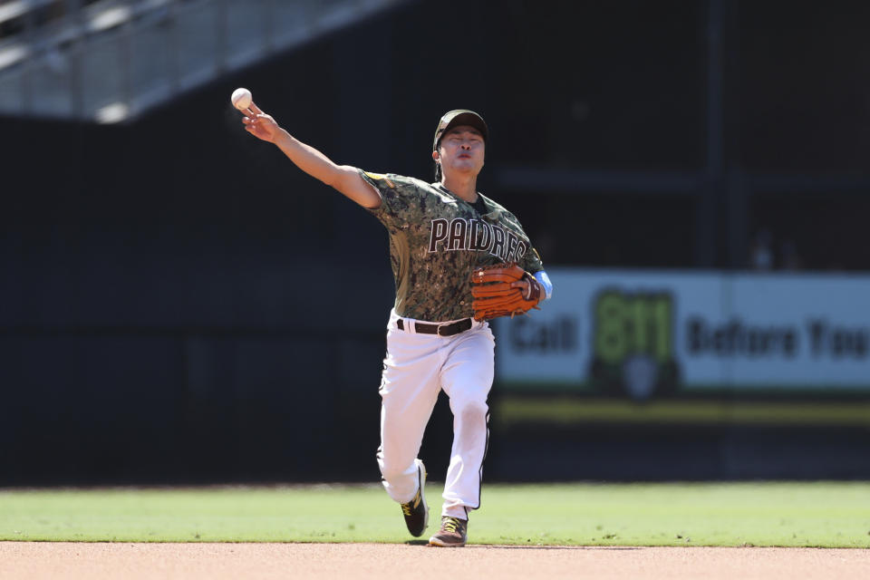 San Diego Padres shortstop Ha-Seong Kim throws to first base after fielding a ground ball hit by Cincinnati Reds' Eugenio Suarez in the seventh inning of a baseball game Sunday, June 20, 2021, in San Diego. Eugenio Suarez was out at first on the play. (AP Photo/Derrick Tuskan)