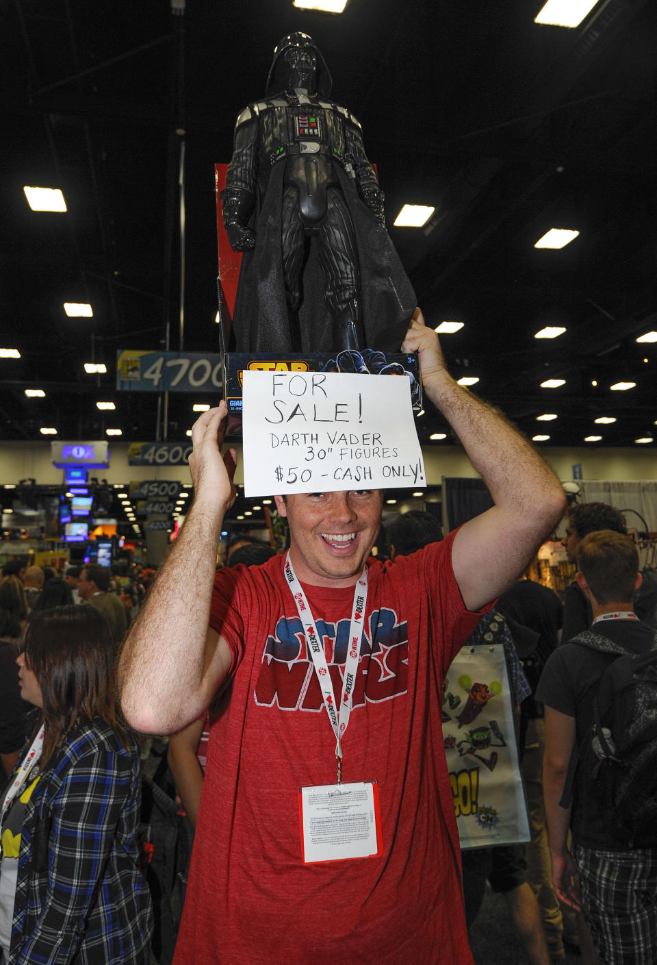 A fan carries a Star Wars Darth Vader figure he has for sale as he walks through the exhibit hall during the Preview Night event on Day 1 of the 2013 Comic-Con International Convention on Wednesday, July 17, 2013 in San Diego. (Photo by Denis Poroy/Invision/AP)