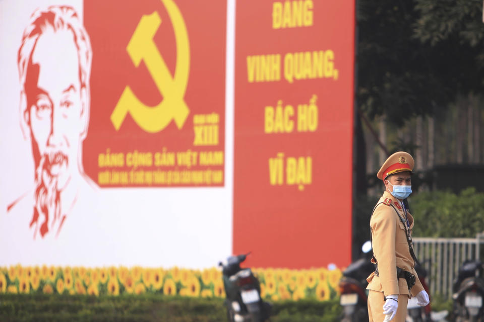 A police officer directs traffic in front of the National Convention Center in Hanoi, Vietnam, Saturday, Jan. 23, 2021. Almost 1,600 leading members of Vietnam's Communist Party on Tuesday, Jan. 26, 2021, begin a meeting to set policy for the next five years and select the group's senior members to steer the nation. (AP Photo/Hau Dinh)