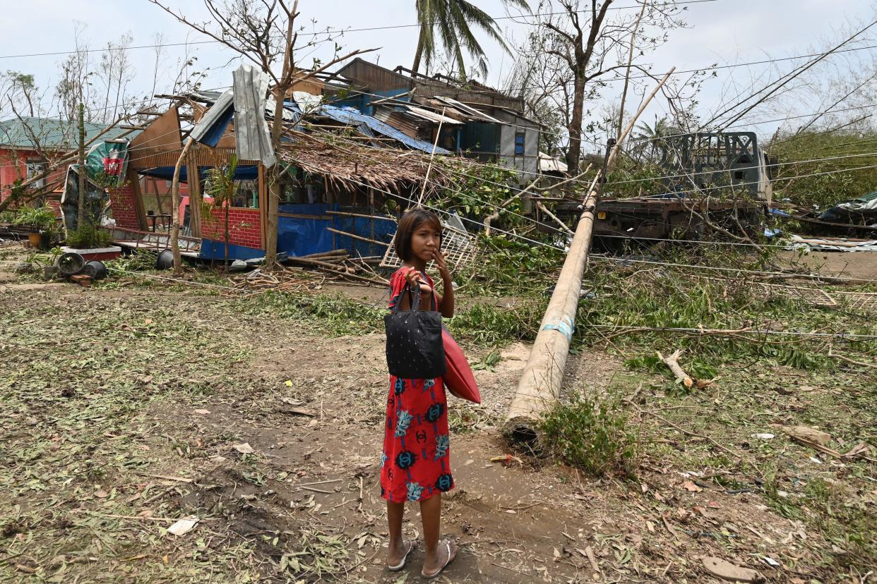 A girl stands in front of a damaged building near Ponnagyun township in Sittwe, Myanmar, on Monday. 