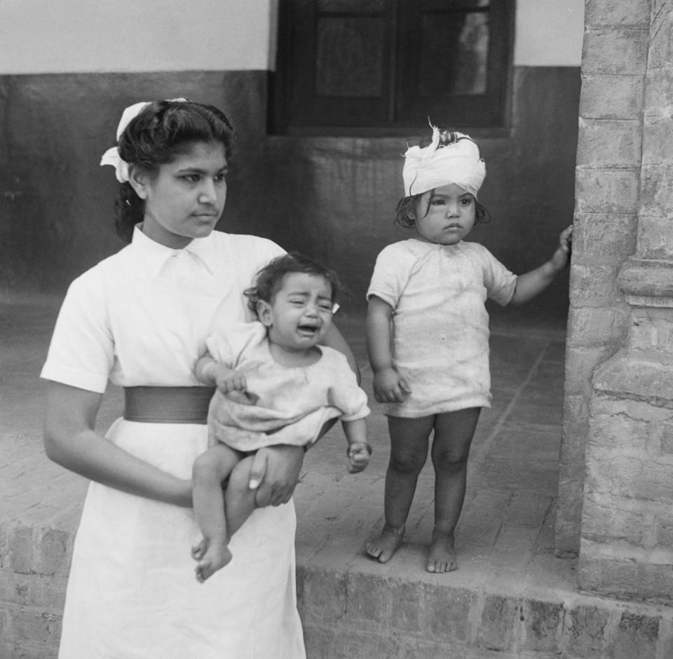 A nurse in Amritsar, India, with two children whose mother was stabbed to death during riots after Partition. <a href="https://www.gettyimages.com/detail/news-photo/nurse-with-two-child-victims-of-communal-violence-in-news-photo/722142427?adppopup=true" rel="nofollow noopener" target="_blank" data-ylk="slk:Keystone Features/Hulton Archive via Getty Images;elm:context_link;itc:0;sec:content-canvas" class="link ">Keystone Features/Hulton Archive via Getty Images</a>