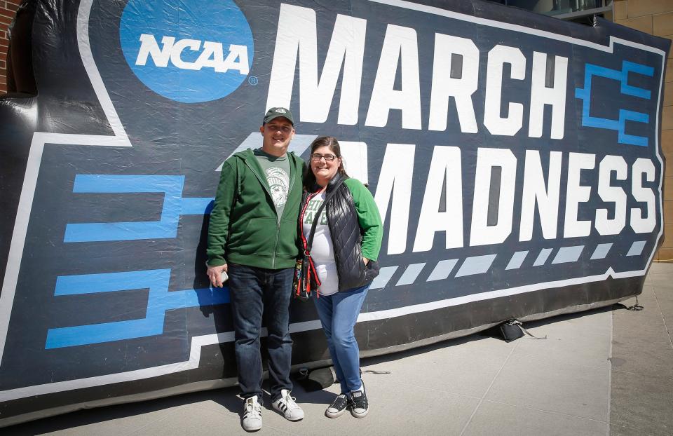 Michigan State fans Brian and Casey Gawronski of Urbandale pose for a photo in front of the March Madness sign outside of Wells Fargo Arena in 2019, the last time the tournament visited Des Moines.
