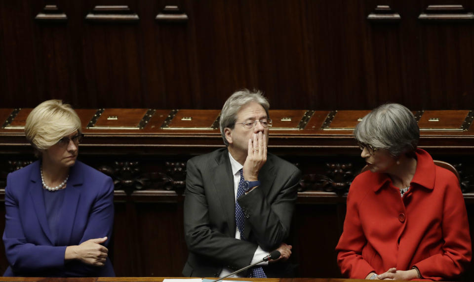 Italian Prime Minister Paolo Gentiloni sits between Anna Finocchiaro, right, and Roberta Pinotti after giving his first speech as premier at the lower house where he will later face a confidence vote, in Rome Tuesday, Dec. 13, 2016. Paolo Gentiloni, a Democrat formerly serving as foreign minister, formed Italy’s new government Monday, keeping several key ministers from the coalition of Matteo Renzi, who resigned last week. (AP Photo/Alessandra Tarantino)