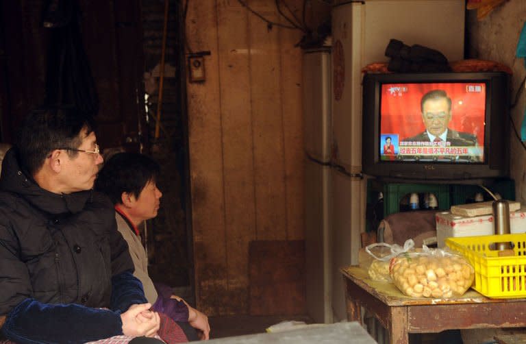 People in Shanghai watch a television set showing Chinese Premier Wen Jiabao speaking during the opening session of the National People's Congress, on March 5, 2013. Chinese inflation hit a 10-month high in February while growth in industrial production and retail sales slowed, official data showed, complicating policymakers' efforts to boost recovery