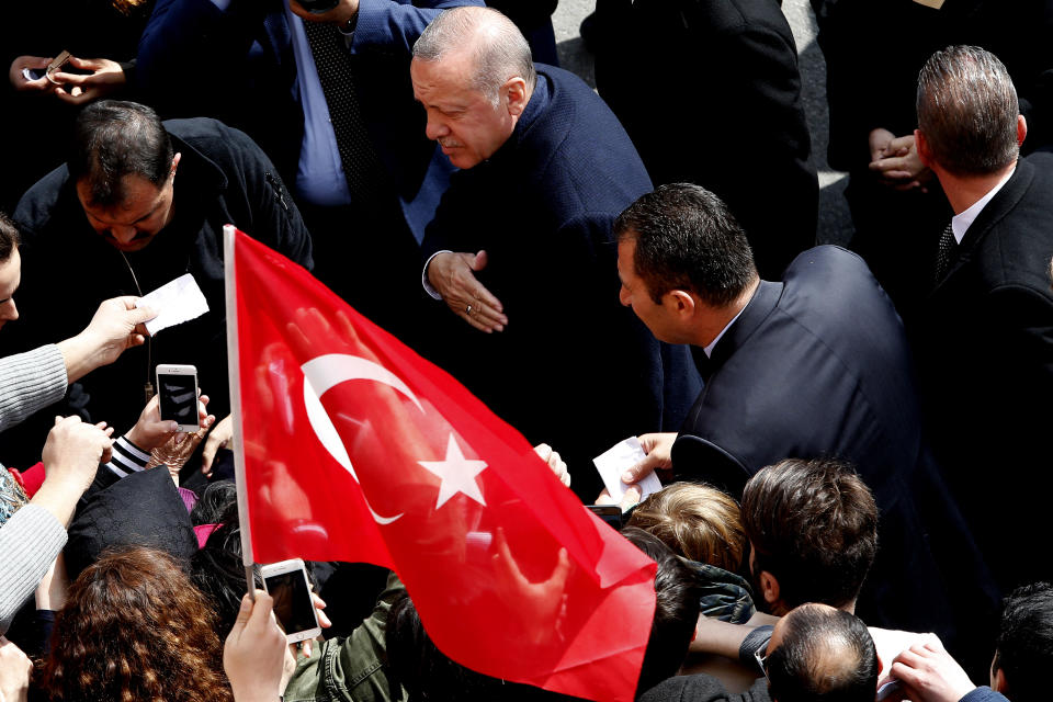 Turkey's President Recep Tayyip Erdogan walks by his supporters at a polling station in Istanbul, Sunday, March 31, 2019. Turkish citizens have begun casting votes in municipal elections for mayors, local assembly representatives and neighbourhood or village administrators that are seen as a barometer of Erdogan's popularity amid a sharp economic downturn.(AP Photo/Lefteris Pitarakis)