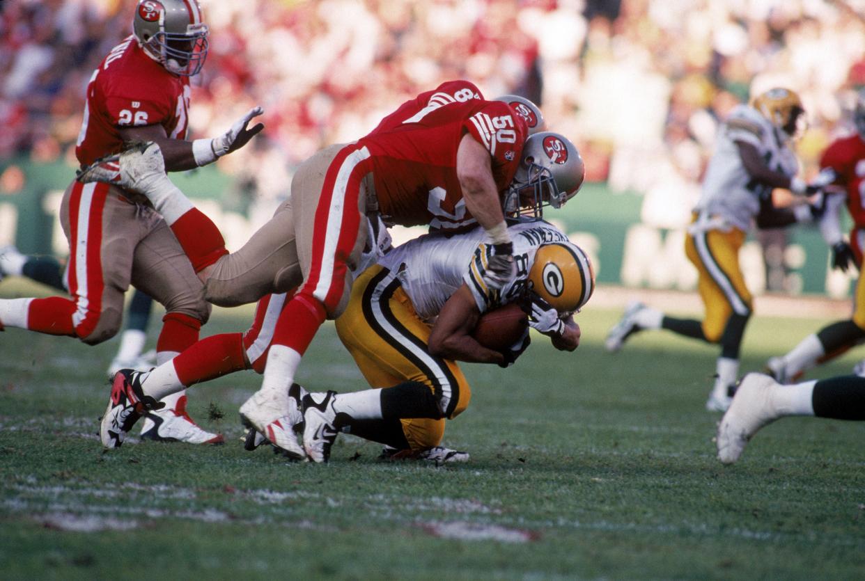 Linebacker Gary Plummer (50), making a tackle in a 1996 playoff game, lasted 12 seasons in the NFL, including four with the San Francisco 49ers. (Getty Images)