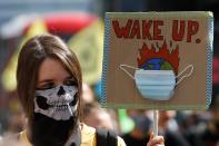 An activist wearing a face covering from the climate protest group Extinction Rebellion holds a placard as she joins a demonstration in Parliament Square in central London on September 1, 2020 as they start their new season of "mass rebellions". - Climate protest group Extinction Rebellion will target Britain's parliament as part of "mass rebellions" starting from September 1. Other actions will take place around the country. (Photo by Tolga AKMEN / AFP) (Photo by TOLGA AKMEN/AFP via Getty Images)