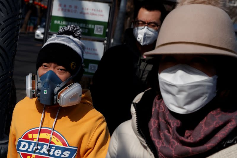 Personas usando máscaras faciales en una calle después del nuevo brote de coronavirus en Pekín, China