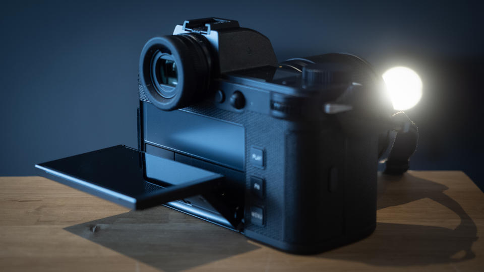 Leica SL3 camera on a wooden surface against a blue background