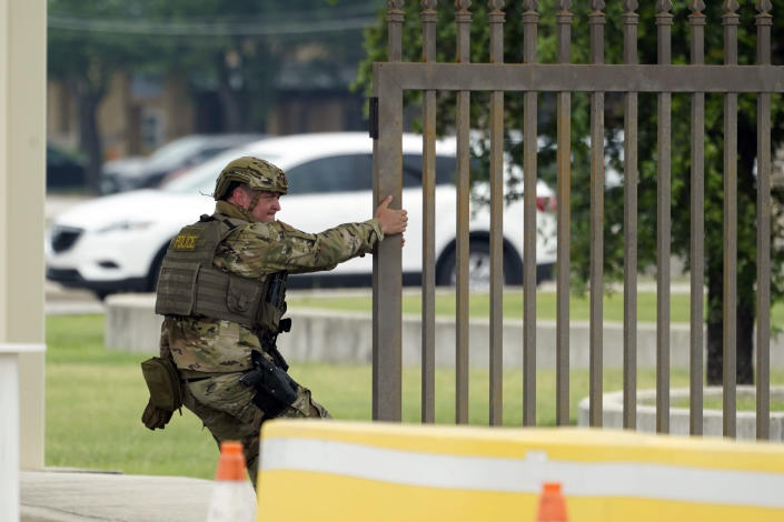 A military policeman closes a gate at JBSA-Lackland Air Force Base, Wednesday, June 9, 2021, in San Antonio. The Air Force was put on lockdown as police and military officials say they searched for two people suspected of shooting into the base from outside. (AP Photo/Eric Gay)