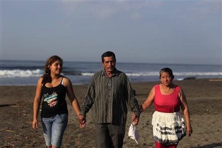 The family of castaway fisherman Jose Salvador Alvarenga -- (L-R) his sister Fatima Orellana, father Jose Ricardo, and mother Maria Julia Alvarenga -- pose for a picture in their fishing hometown of Ahuchapan February 4, 2014. REUTERS/ Ulises Rodriguez