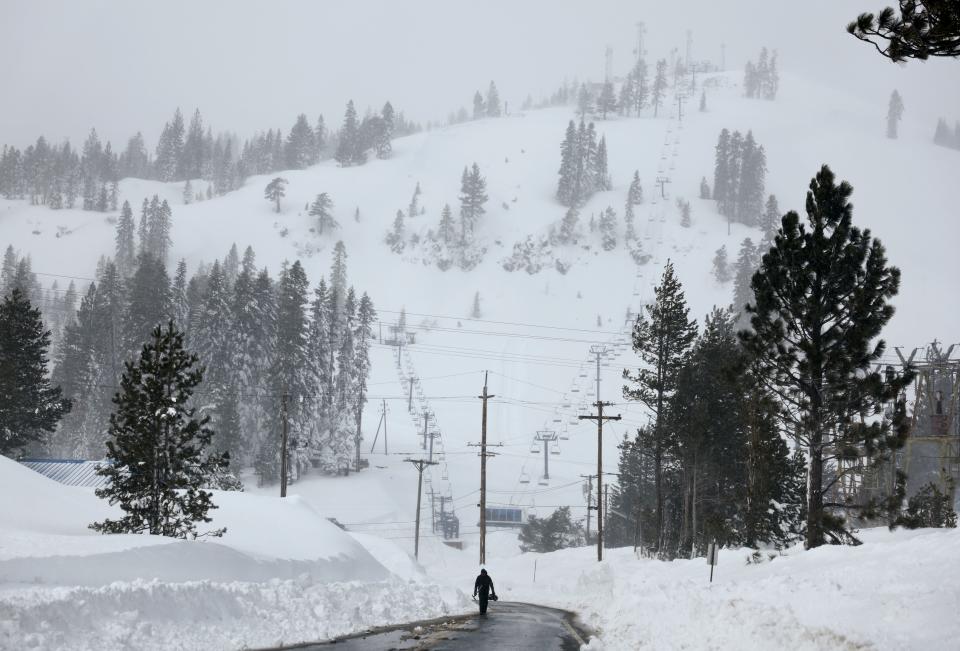 A person walks near a ski resort, currently shuttered due to the storm, following a massive snowstorm in the Sierra Nevada mountains on March 4, 2024 near Soda Springs, California.