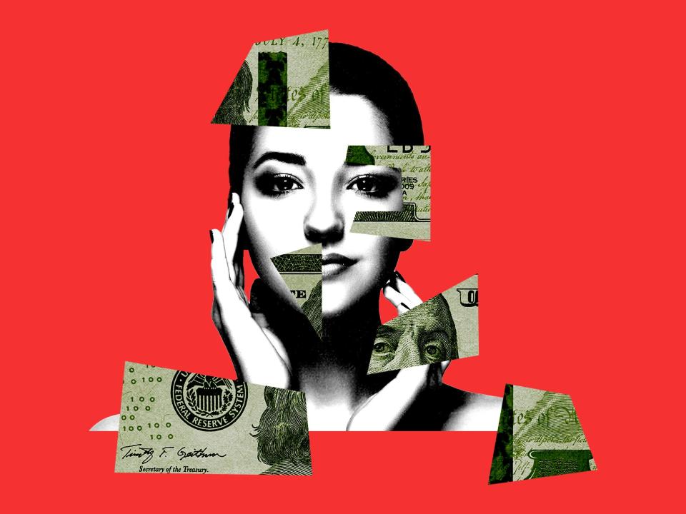 A woman's face partially covered by money