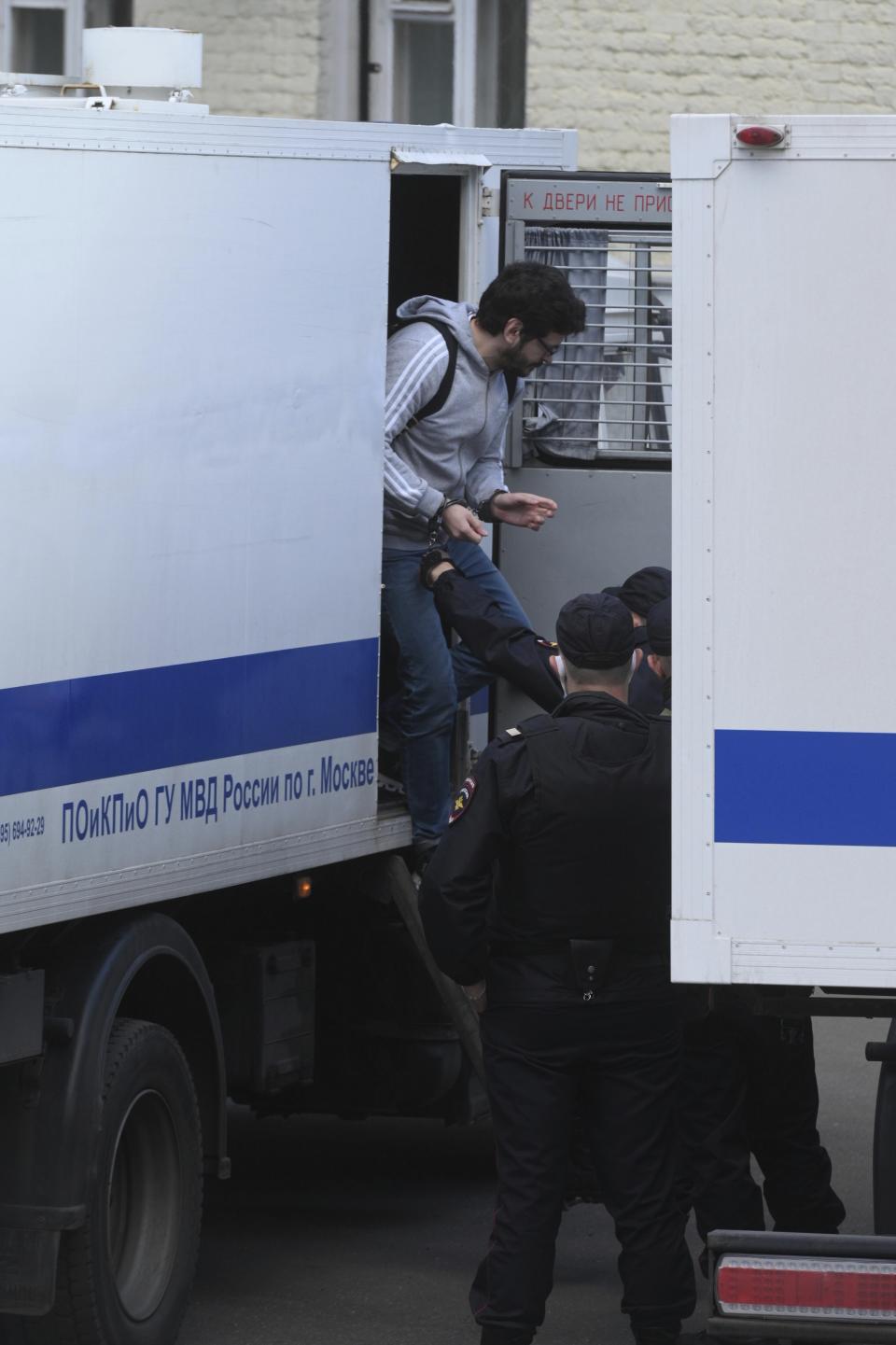 Russian opposition activist and municipal deputy of the Krasnoselsky district Ilya Yashin, top, steps down from a police truck to attend a hearing on his detention, at the Basmanny district court in Moscow, Russia, Friday, Sept. 9, 2022. Yashin, 39, is one of the few prominent opposition figures that refused to leave Russia despite the unprecedented pressure the authorities have mounted on dissent in recent years. (AP Photo/Dmitry Serebryakov)