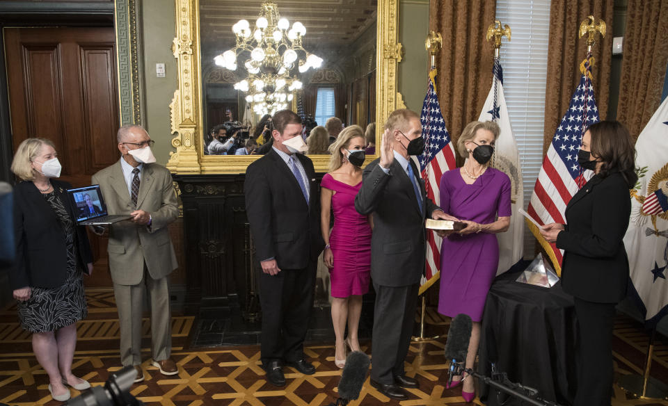 In this photo provided by NASA, former U.S. Sen. Bill Nelson, is ceremonially sworn-in as the 14th NASA Administrator by Vice President Kamala Harris, as his wife, Grace Nelson, holds their family Bible, accompanied by son, Bill Nelson Jr., third from left, and Nan Ellen Nelson, fourth from left, at the Ceremonial Office in the Old Executive Office Building in Washington on Monday, May 3, 2021. A moon rock collected by astronaut John Young during the Apollo 16 mission was on display and former NASA Administrators Jim Bridenstine (virtually on laptop) and Charles Bolden, second from left, were also present. (Aubrey Gemignani/NASA via AP)