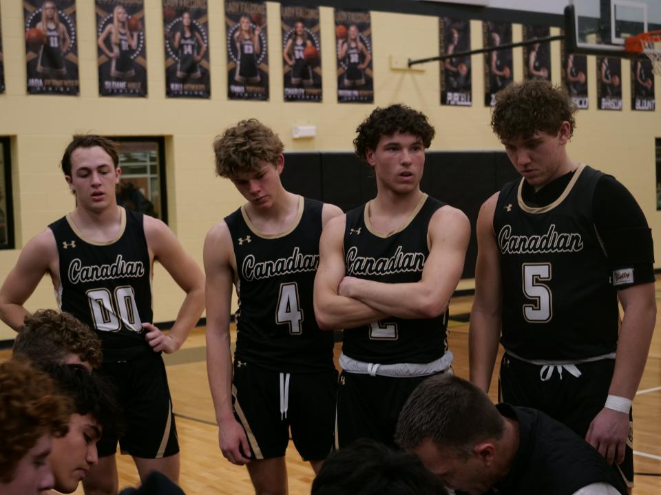 Canadian's Luke Flowers (00), Preston Miller (4), Trace Mitchell (2) and Nathan Wagner (5) huddle during a timeout against Bushland on Tuesday, February 7, 2023 at Bushland High School.