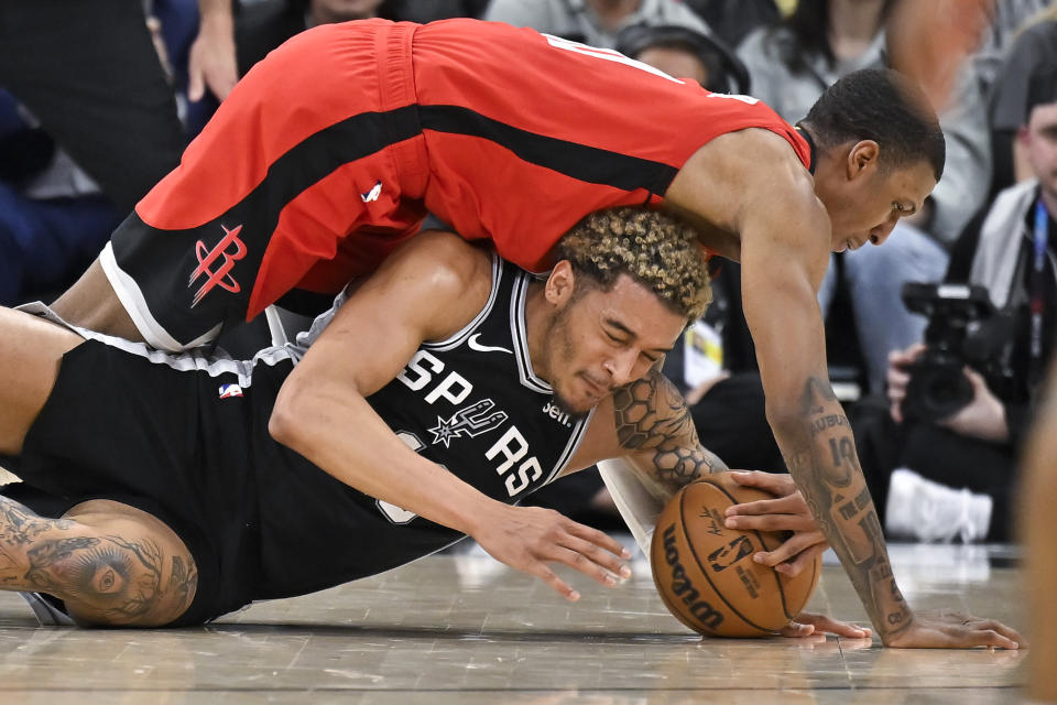 San Antonio Spurs' Jeremy Sochan, bottom, tangles with Houston Rockets' Jabari Smith Jr. during the first half of an NBA basketball game, Tuesday, March 12, 2024, in San Antonio. (AP Photo/Darren Abate)