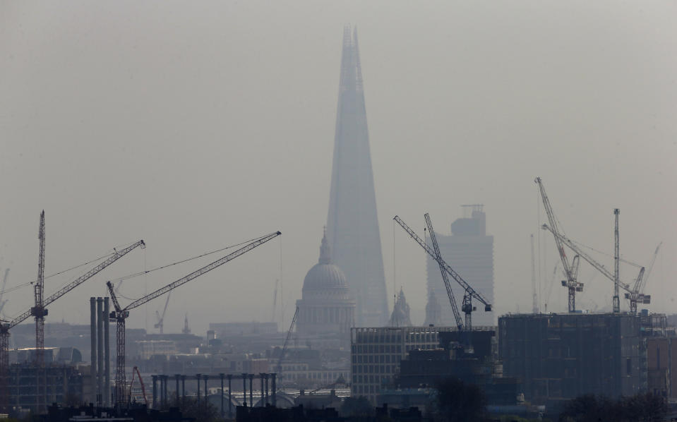 Building construction cranes frame The Shard, western Europe's tallest building, and St Paul's Cathedral in London. Photo: Suzanne Plunkett/Reuters