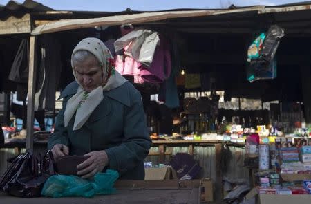 An elderly woman counts money at a market in the town of Tkvarcheli, some 50 km (31 miles) southeast of Sukhumi, the capital of Georgia's breakaway region of Abkhazia December 27, 2013. REUTERS/Maxim Shemetov/Files