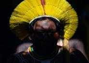 An indigenous tribesman listens to Metuktire during a press conference in Piaracu village, near Sao Jose do Xingu in Brazi's Mato Grosso state