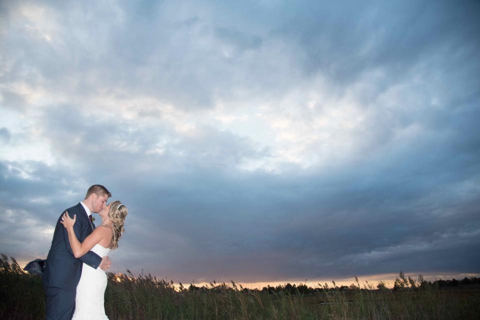 <p>With the passing of her mom a few years back, Jackie and her husband Mike wanted to be sure that she was still very much a part of their wedding. "My mom was buried here, so this picture was a special moment between the three of us." – Jackie</p>