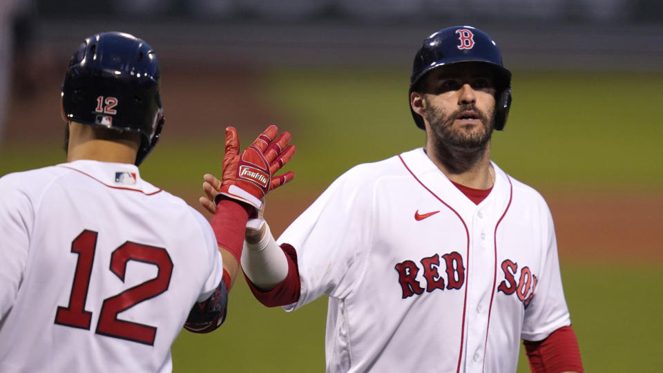 Boston Red Sox's J.D. Martinez, right, is congratulated by Marwin Gonzalez (12) after scoring on a single by Christian Vazquez during the first inning of a baseball game against the Detroit Tigers at Fenway Park, Tuesday, May 4, 2021, in Boston. (AP Photo/Charles Krupa)