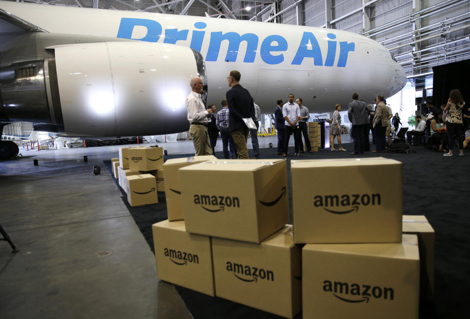 FILE - In this Aug. 4, 2016 file photo, Amazon.com boxes are shown stacked near a Boeing 767 Amazon "Prime Air" cargo plane on display in a Boeing hangar in Seattle. Amazon’s Prime shipping program set the pace for shoppers’ expectations, and the nation’s largest online player continues to look for new ways to keep up with shoppers’ demands. (AP Photo/Ted S. Warren, File)