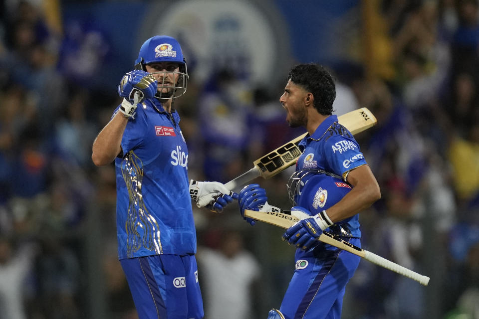 Mumbai Indian's Tilak Varma, right, celebrates along with Mumbai Indian's Tim David their team win against Rajasthan Royals during the Indian Premier League cricket match in Mumbai, India, Sunday, April 30, 2023. (AP Photo/Rajanish Kakade)