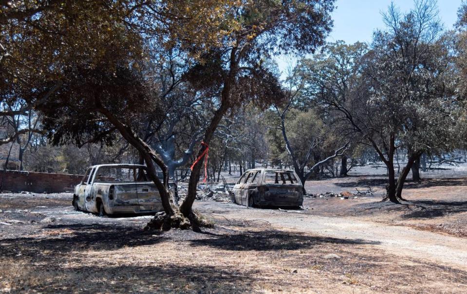 Burned cars sit near a driveway next to rubble from a destroyed home in Oroville on Wednesday. So far, 13,000 people have been evacuated in the Thompson fire.