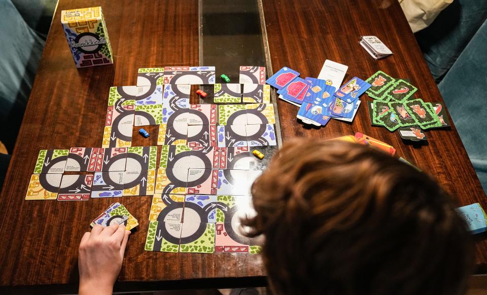 Franklin Vrtis lays out cards to his game he developed called Roundabouts. The card game is based on the hundreds of roundabouts in Carmel. Photographed on Thursday, Feb. 23, 2023 at their family home in Carmel. 