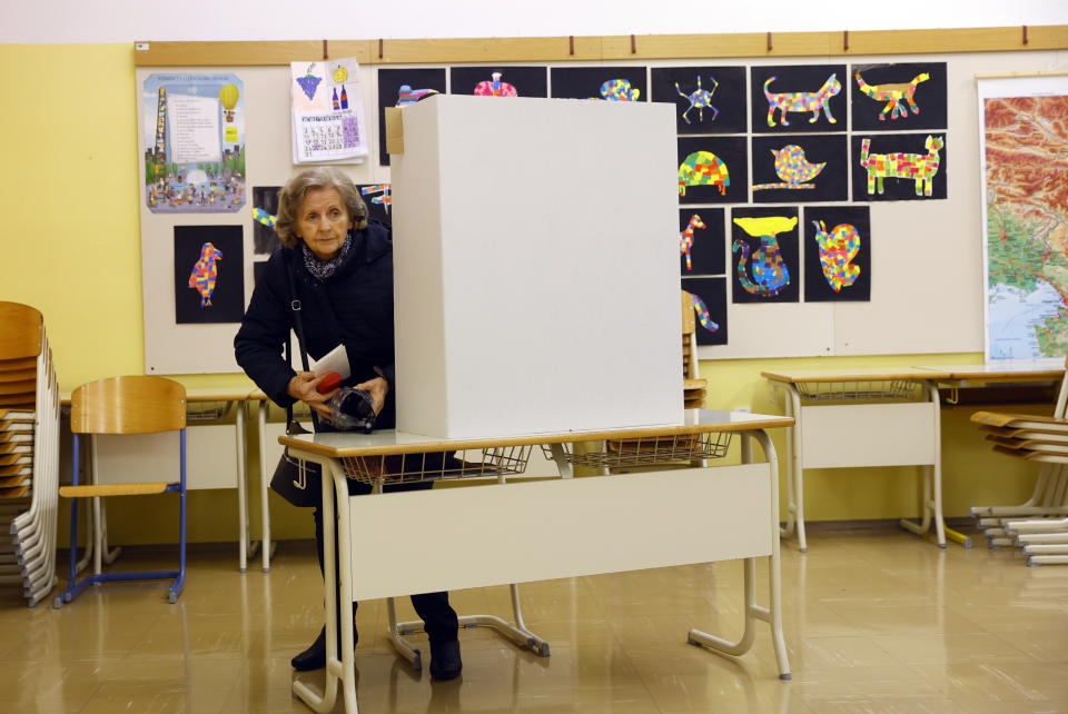 A woman prepares her ballot for a presidential election at a poling station in Ljubljana, Slovenia, Sunday, Oct. 23, 2022. Voters in Slovenia on Sunday cast ballots to elect a new president of the European Union nation, with three main contenders leading the race but no clear winner in sight. (AP Photo)