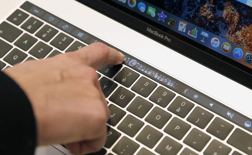 PARIS, FRANCE - DECEMBER 01:  An attendee touches the Touch Bar on the new MacBook Pro laptop computer inside the new Apple store Saint Germain during the press day on December 01, 2016 in Paris, France. On December 3, Apple will inaugurate and open its new Apple store to the public at the 