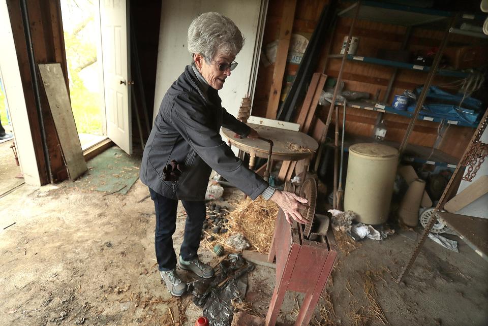 Barbie Ream, one of nine children to grow up on the Floom farm in Jackson Township, tests an old machine her father used to remove the hard kernels off the corn cobs. The property is set to be auctioned later this month.