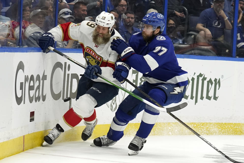 Florida Panthers center Joe Thornton (19) and Tampa Bay Lightning defenseman Victor Hedman (77) chase a loose puck during the first period in Game 4 of an NHL hockey second-round playoff series Monday, May 23, 2022, in Tampa, Fla. (AP Photo/Chris O'Meara)